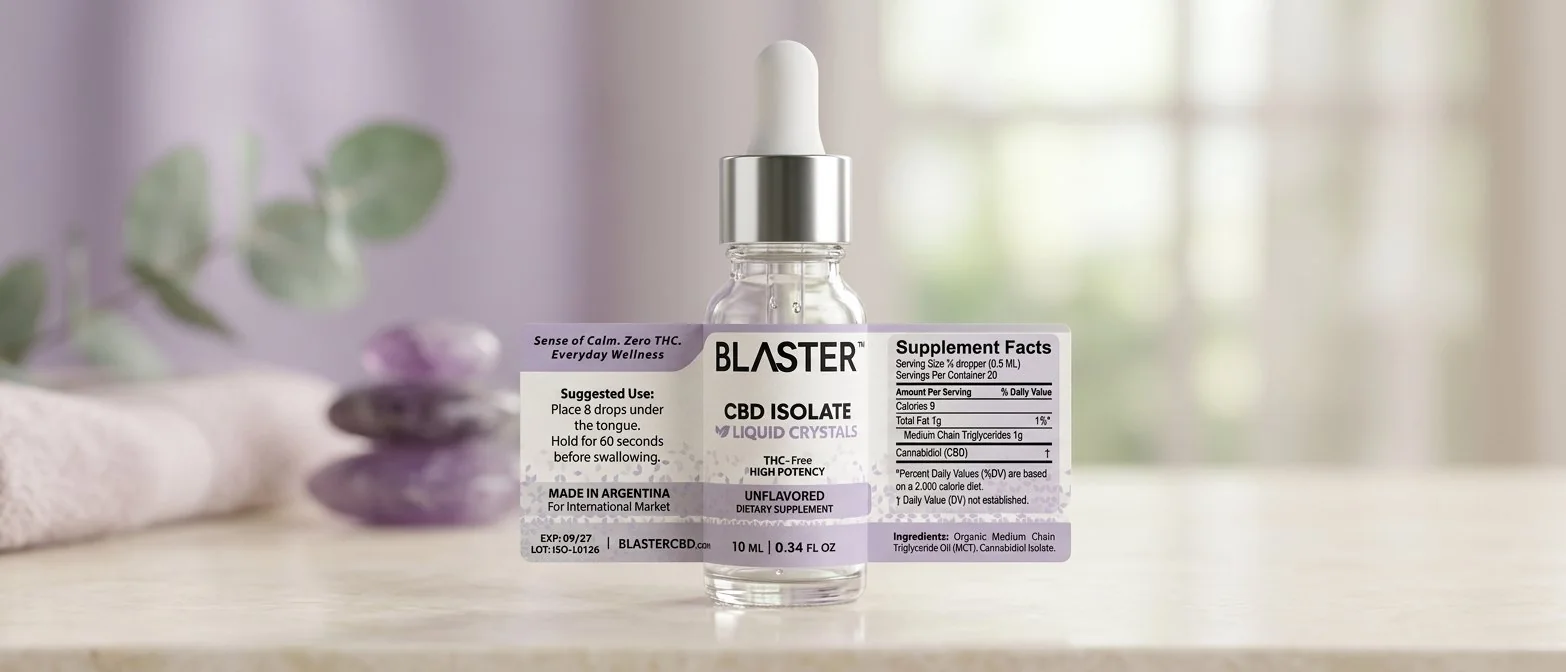 Frasco de 10 ml BLASTER™ ISOLATE con gotero blanco y etiqueta lila, sobre una mesa clara con piedras de amatista